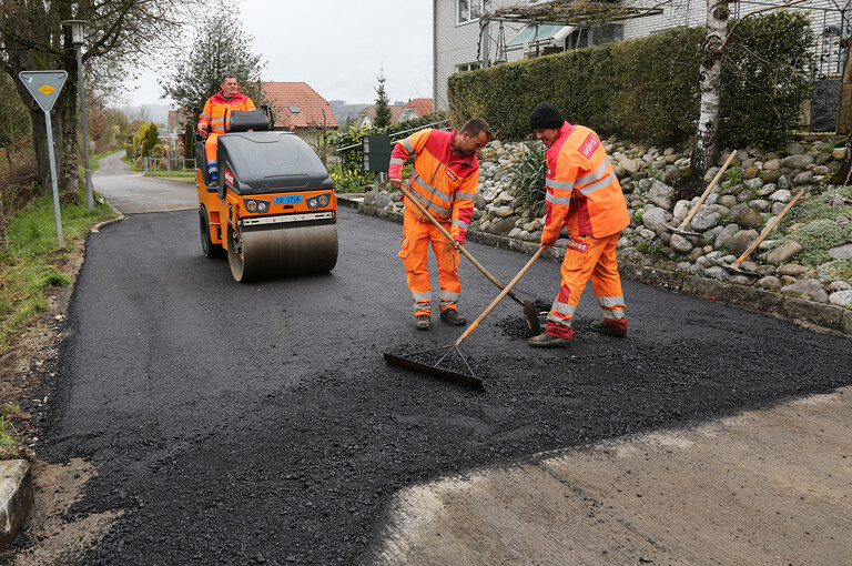 Bauarbeiter beim Einbau des Asphaltbelags auf der Güter- und Gemeindestrasse in Alberswil Walze.