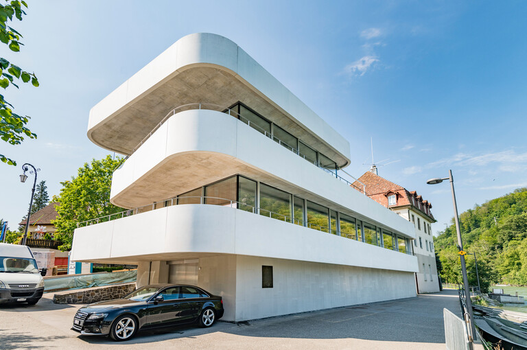 Moderner Neubau eines Landhauses in Aarburg mit geschwungenen weissen Balkonen, grossen Fensterfronten und klarer Architektursprache.